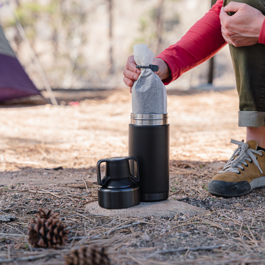 Adding a filter with coffee into the Gunmetal and Black Toddy Go Brewer while camping