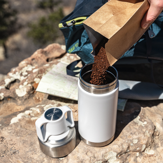 Adding coffee to the Toddy Go Brewer in the outdoors on a hike.