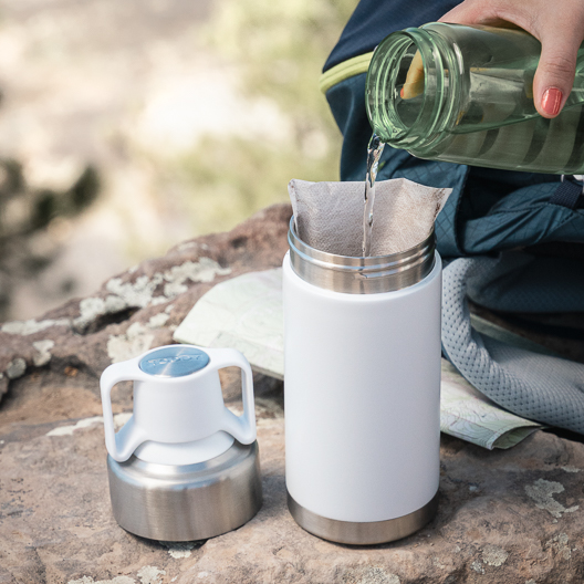 Adding water to the Toddy Go Brewer in the outdoors on a hike