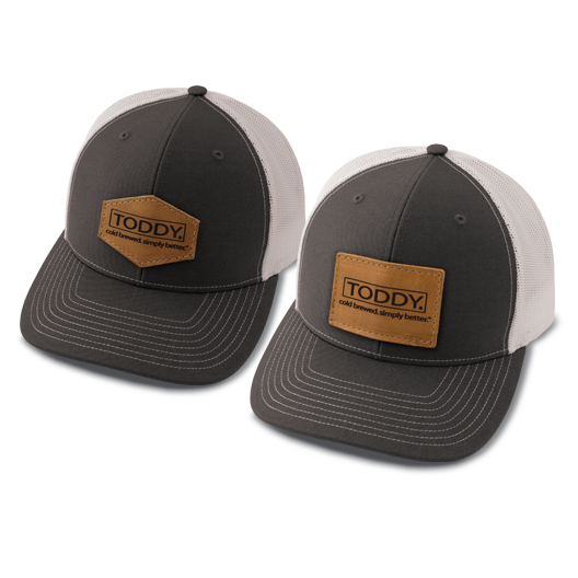 close up shot of Toddy merchandise trucker hats side by side with different patch styles