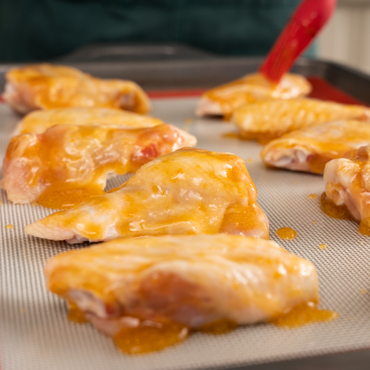 Basting the chicken wings with apricot tea marinade