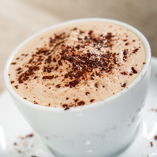 Cold brewed mocha with shaved chocolate in a cup with saucer