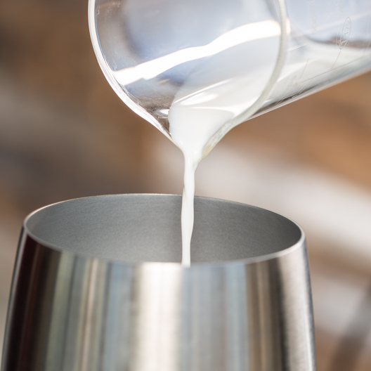 pouring milk into stainless for frothing