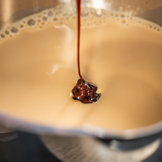 Adding chocolate syrup to concentrate and milk mixture